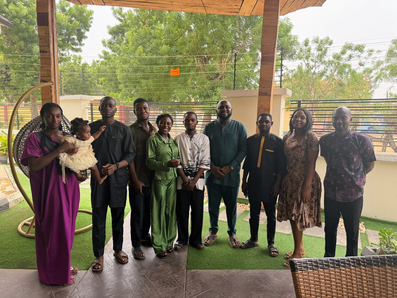 Ikegbunem Ugochukwu standing with a group of team members on a covered patio.