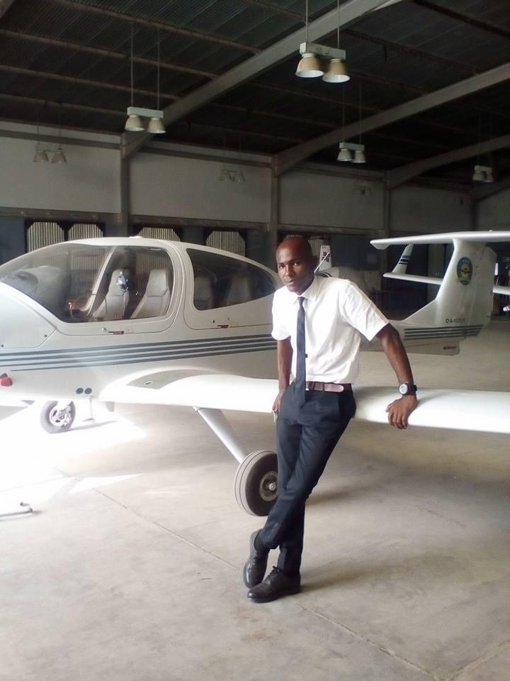 Ugochukwu leaning on the wing of a small aircraft in a hangar.